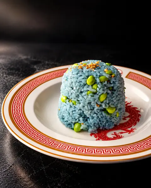 Butterfly pea rice with edamame on a dragon plate