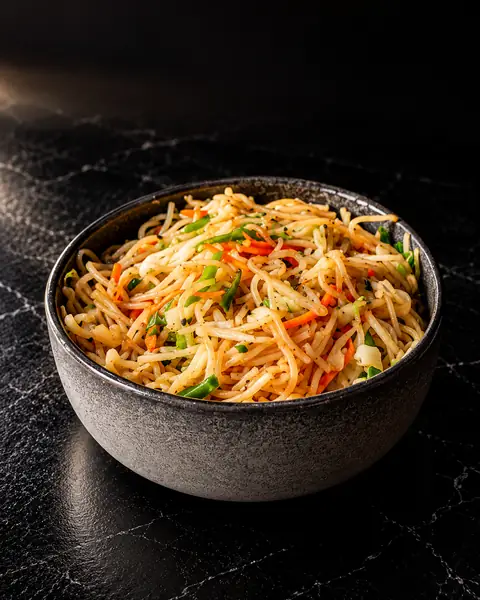 Vegetable hakka noodles in a stone bowl